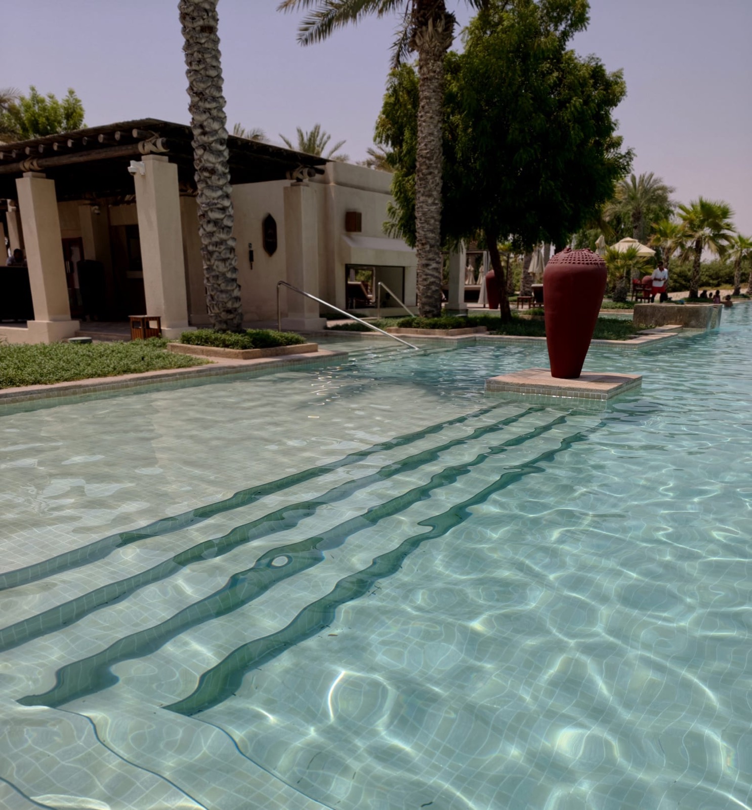 Ruhiger Pool zwischen Palmen und arabischer Architektur