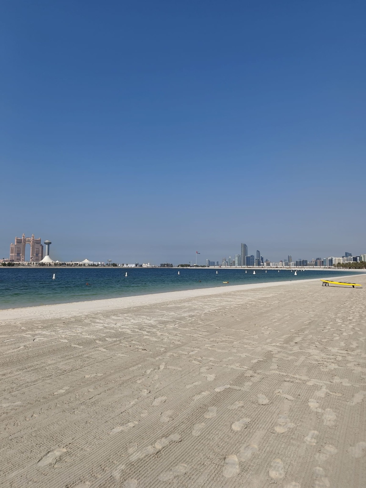 Weißer Sandstrand mit Blick auf die Skyline von Abu Dhabi