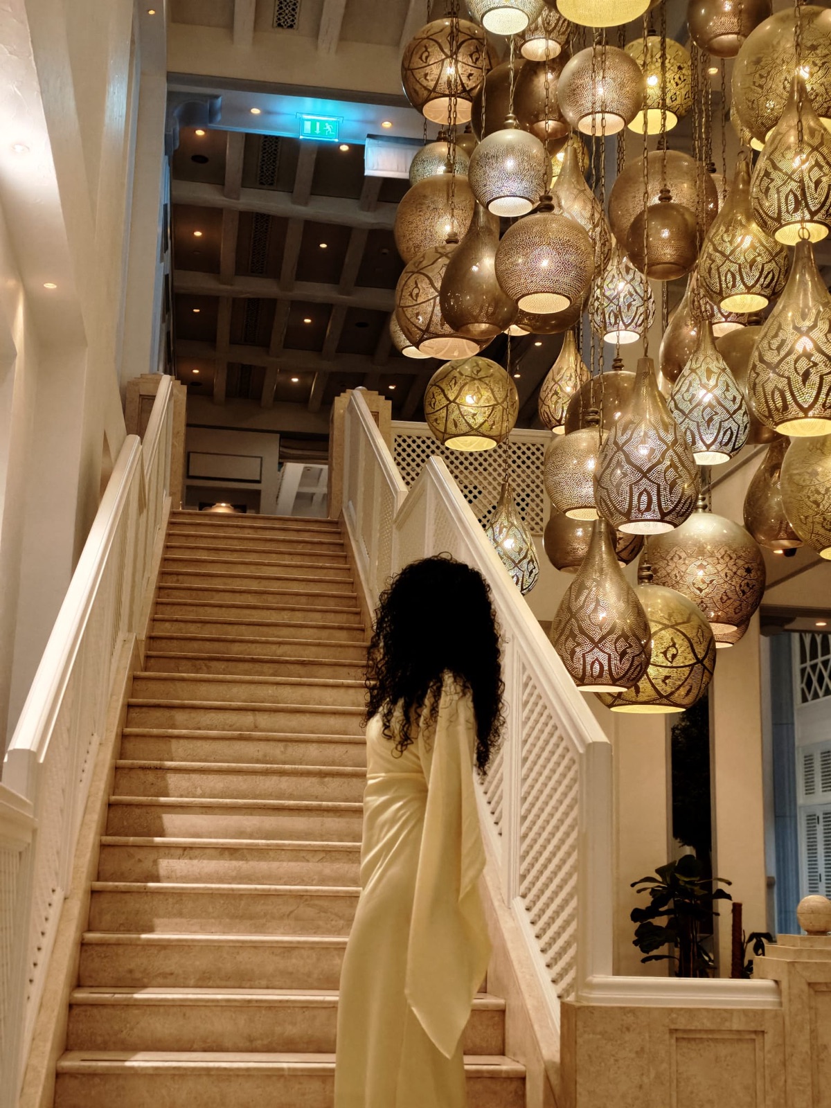 Ausdrucksstarke Hoteltreppe mit goldenen Hängeleuchten