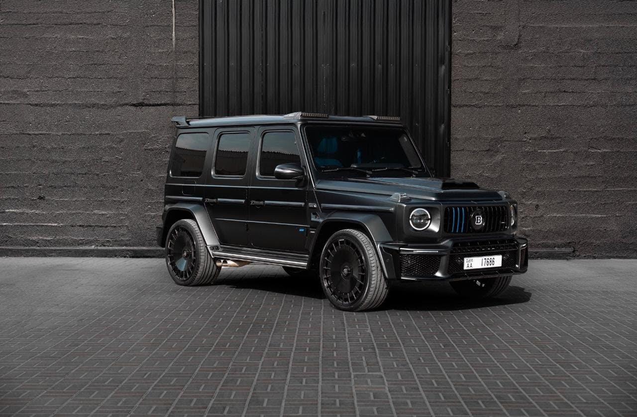 Schwarze Mercedes G-Klasse vor einer dunklen Fassade